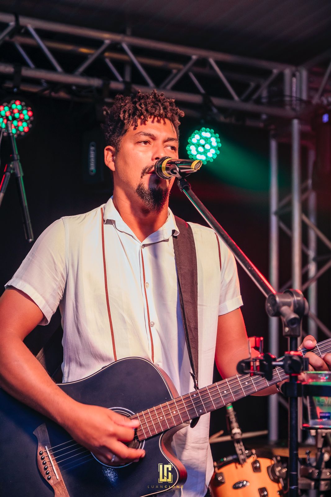 Will cantando ao microfone e tocando violão